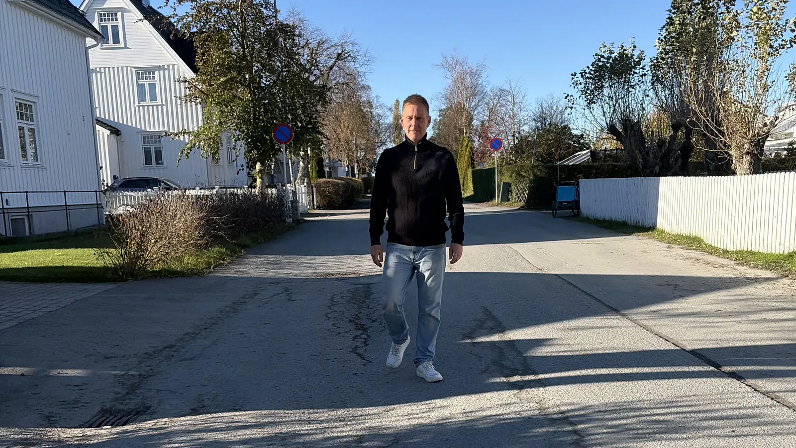 Gaute Talmo går midt i en solfylt villavei